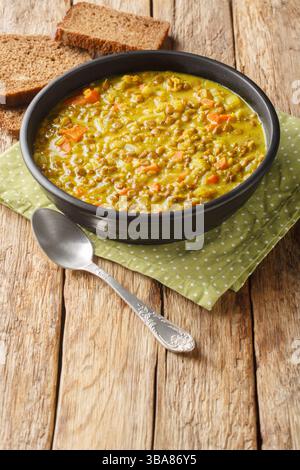 Detox Linsensuppe enthält entzündungshemmende Inhaltsstoffe wie Kurkuma, Zitrone und Ingwer in der Nahaufnahme auf dem Teller auf dem Tisch. Vertikal Stockfoto