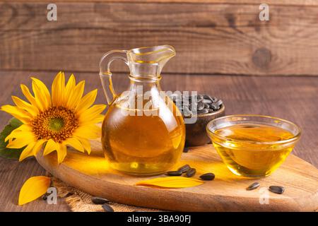 Sonnenblumenöl und Sonnenblumenkerne auf traditionellem rustikalem hölzernem Hintergrund. Bio- und Öko-Food-Konzept. Gesunde Lebensmittel und Fette. Stockfoto