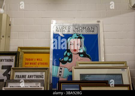 Manchester, Großbritannien - 11.16.2024: Ein Galerieeinrichtungsraum mit gerahmten Pop-Art-Stücken, die an einer gekachelten Wand befestigt sind. Stockfoto