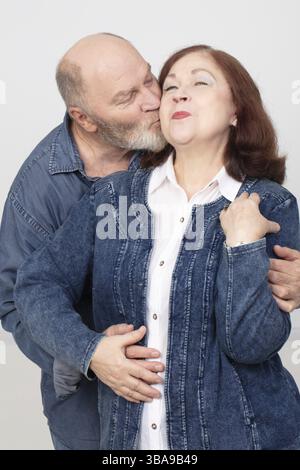 Porträt eines verliebten älteren Ehepaares, ein liebevoller erwachsener Ehemann küsst seine schöne Frau Stockfoto