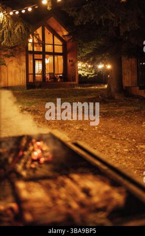 Nahaufnahme eines abendlichen Barbecue im Hinterhof des Hauses. Köstliches saftiges, duftendes Fleisch auf dem Grill und brennende Holzkohle. Leckeres Essen im Freien. Tr Stockfoto