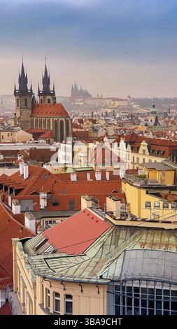 Prager Rotdächer und Türme der historischen Prager Altstadt. Das Stadtbild von Prag bei einem frostigen Sonnenuntergang. Rote Dächer, Türme und Prager Burg in der BA Stockfoto