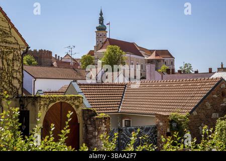 Malerische Stadt Mikulov am sonnigen Frühlingstag mit blühenden Büschen und Bäumen. Mikulov, ausgebreitet auf den Hügeln von Palava und umgeben von Weinbergen Stockfoto