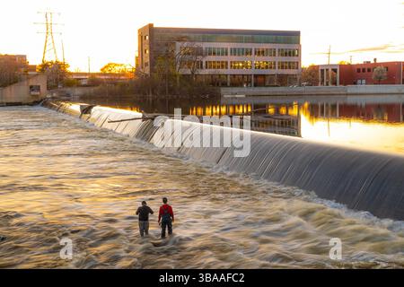 Grand Rapids, MI, USA - 23.04.2025: Foto von Menschen, die am Fluss in Grand Rapids Michigan angeln und entspannen während des Sonnenuntergangs mit malerischer Aussicht und Kal Stockfoto