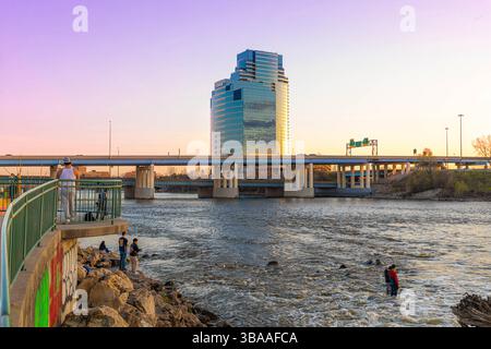 Grand Rapids, MI, USA - 23.04.2025: Foto von Menschen, die am Fluss in Grand Rapids Michigan angeln und entspannen während des Sonnenuntergangs mit malerischer Aussicht und Kal Stockfoto