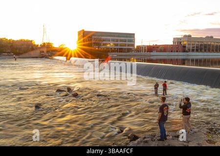 Grand Rapids, MI, USA - 23.04.2025: Foto von Menschen, die am Fluss in Grand Rapids Michigan angeln und entspannen während des Sonnenuntergangs mit malerischer Aussicht und Kal Stockfoto