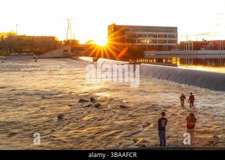 Grand Rapids, MI, USA - 23.04.2025: Foto von Menschen, die am Fluss in Grand Rapids Michigan angeln und entspannen während des Sonnenuntergangs mit malerischer Aussicht und Kal Stockfoto