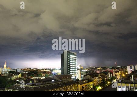 Dramatische Nachtsicht auf Novi Sad, Serbien, während eines Gewitters. Blitze erleuchten den Himmel über den Gebäuden der Stadt und erzeugen eine Stimmung. Stockfoto