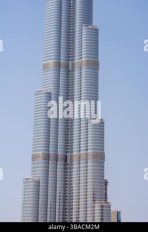 Ein moderner Wolkenkratzer mit schlanker Glasfassade aus nächster Nähe, der sein einzigartiges architektonisches Design und mehrere Ebenen zeigt. Stockfoto