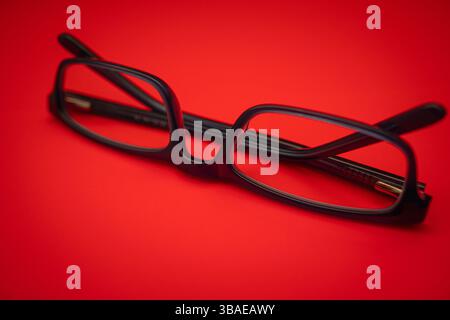 Brille auf rotem Hintergrund. Stockfoto