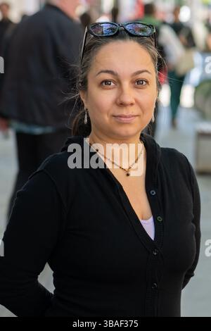 Straßenszene mit einer 40-45-jährigen Frau, die direkt in die Kamera schaut Stockfoto