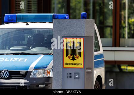 11. Mai 2025, Baden-Württemberg, Karlsruhe: Am 28. März 2025 sind auf einer Stele vor dem Hauptgebäude des Bundesverfassungsgerichts (BVerfG) in Karlsruhe (Baden-Württemberg) der Schriftzug „Bundesverfassungsgericht“ und ein deutscher Bundesadler zu sehen, dahinter stehen Rettungsfahrzeuge der Bundespolizei auf dem Gelände. Als Verfassungsgericht der Bundesrepublik Deutschland ist das Bundesverfassungsgericht sowohl ein autonomes als auch unabhängiges Verfassungsorgan der Justiz, das gleichrangig mit den anderen Obersten Bundesorganen und dem Obersten Gericht ist Stockfoto