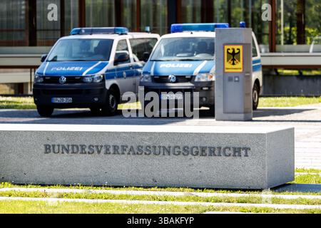 11. Mai 2025, Baden-Württemberg, Karlsruhe: Am 28. März 2025 sind auf einer Stele vor dem Hauptgebäude des Bundesverfassungsgerichts (BVerfG) in Karlsruhe (Baden-Württemberg) der Schriftzug „Bundesverfassungsgericht“ und ein deutscher Bundesadler zu sehen, dahinter stehen Rettungsfahrzeuge der Bundespolizei auf dem Gelände. Als Verfassungsgericht der Bundesrepublik Deutschland ist das Bundesverfassungsgericht sowohl ein autonomes als auch unabhängiges Verfassungsorgan der Justiz, das gleichrangig mit den anderen Obersten Bundesorganen und dem Obersten Gericht ist Stockfoto