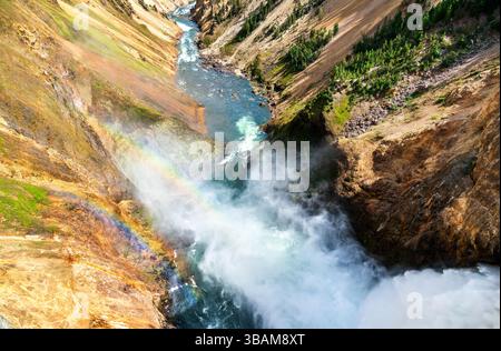 Nebel der mächtigen Lower Falls im Yellowstone National Park erzeugt einen lebhaften Regenbogen über dem Grand Canyon des Yellowstone und verleiht der rauen Landschaft Farbe. UNESCO-Weltkulturerbe in Wyoming Stockfoto