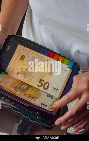 Das offene Portemonnaie zeigt verschiedene Banknoten und farbenfrohe Kartenfächer, die persönliche Finanzen hervorheben. Hochwertige Fotos Stockfoto