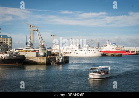 Touristenboote fahren in den Hafen an der V&A Waterfront in Kapstadt, mit dem Tafelberg im Hintergrund. Südafrika. Stockfoto