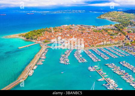 Ein atemberaubender Blick aus der Vogelperspektive auf Izola, Slowenien, mit seinem pulsierenden Yachthafen voller Boote und dem farbenfrohen historischen Stadtzentrum Stockfoto