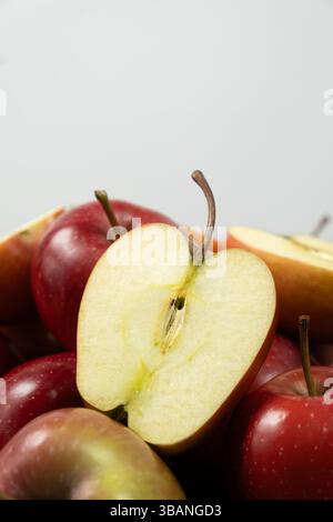 Gruppe frischer roter ganzer Äpfel und Apfelhälften Nahaufnahme. Stockfoto