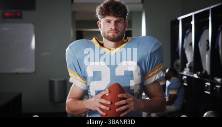 Athlet, Fußballspieler oder Ball im Umkleideraum für Porträt, Schutzausrüstung oder Quarterback im Turnier. Nationalsport, ernsthaft oder man in Stockfoto