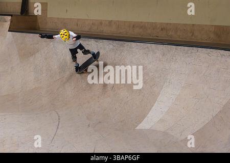 Skateboarden für Kinder in einem Skatepark, mit einem Trick Stockfoto