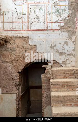Terrassenhäuser, Ephesus – fragmentierte rot-weiße Wandmalerei über einer gemauerten Nische, die römische Wohndesign-Details darstellt. Stockfoto