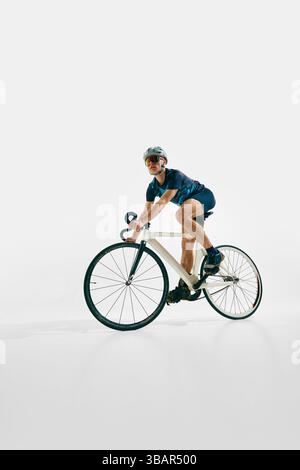 Seitenansicht, niedriges Bild des fokussierten Mannes, Profi-Radfahrer in Vollausrüstung, Fahrrad fahren, Training isoliert auf weißem Hintergrund. Stockfoto