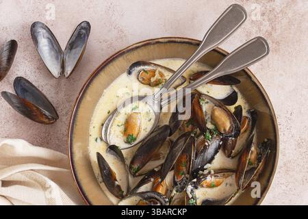 Muscheln in cremiger Knoblauchsauce, serviert mit frischen Kräutern und Gewürzen, hausgemacht, keine Leute Stockfoto