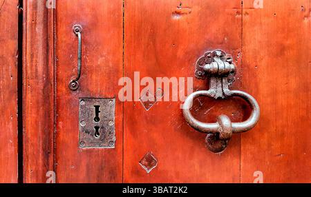 Rote Vintage-Holztür mit metallischem Türgriff und Schlüssellöchern, Troyes, Frankreich Stockfoto