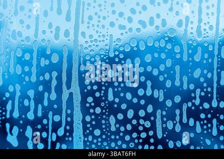 Hellblaue abstrakte Textur mit Seifenschaummuster auf Glas Stockfoto