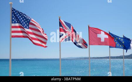 Die Flaggen der Vereinigten Staaten, Großbritanniens, der Schweiz und der Europäischen Union im Wind an der Küste von Nizza, Frankreich Stockfoto
