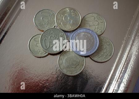 Mehrere Euro-Münzen auf einem goldenen Tablett Stockfoto