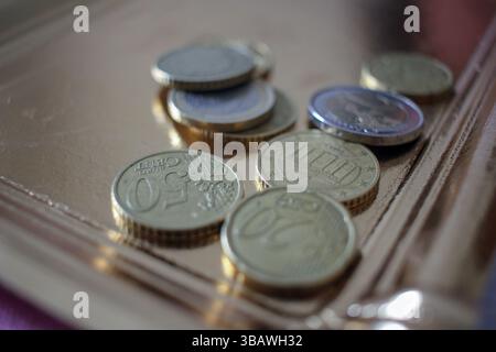 Einige Euro-Münzen auf einem goldenen Tablett, um die Rechnung zu bezahlen Stockfoto