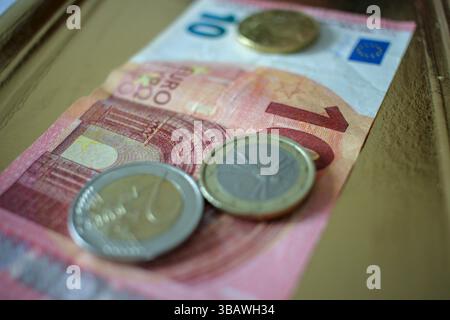 Einige Münzen und eine 10-Euro-Banknote auf einem Tablett Stockfoto