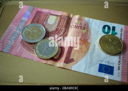 Einige Euro-Münzen und eine zehn-Euro-Banknote auf einem Tablett Stockfoto