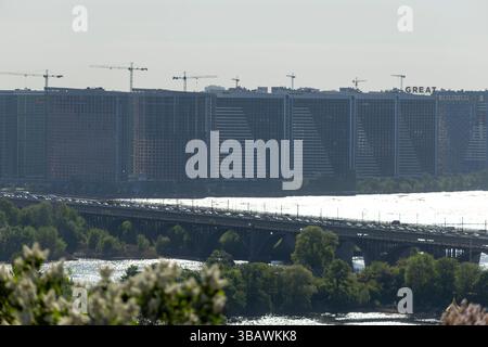 2025.05.01, Kiew, Ukraine: Blick auf einen Wohnkomplex in einer Großstadt, der sich im Bau befindet und mit Kränen über teilweise bebauten Bauten thront. Stockfoto