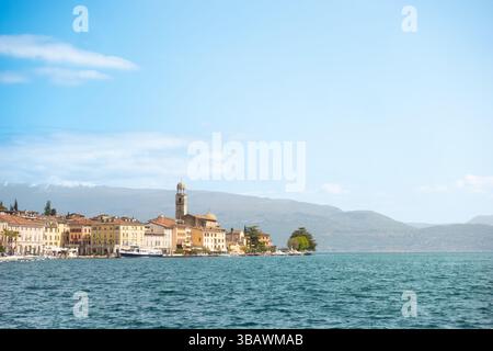 Panoramablick auf die Küstenstadt Salò am Gardasee mit dem berühmten Kirchturm vor den alpen im Hintergrund an klaren Tagen Stockfoto