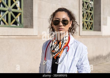 Porträt einer ernsthaften Ärztin mit Sonnenbrille und Stethoskop, die außerhalb des Krankenhauses steht Stockfoto