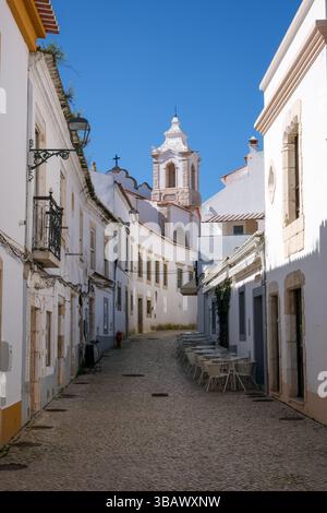 01.03.2025, Portugal, Algarve, Lagos - Gassen in der Altstadt von Lagos, Gasse in der Fußgängerzone. Santo Antonio Kirche hinten. 00X2503 Stockfoto