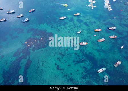 Luftdrohne mit Blick auf kleine Boote auf klarem, grün türkisfarbenem Meereswasser Stockfoto