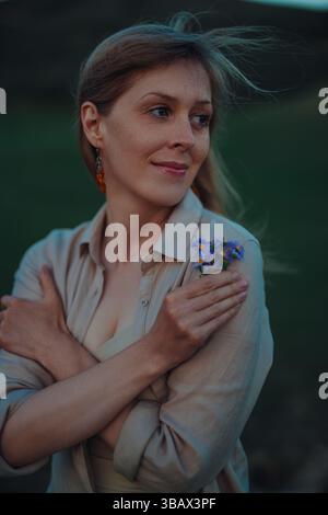 Porträt einer jungen schönen Frau im Freien mit einem Blumenstrauß aus Wildblumen Stockfoto