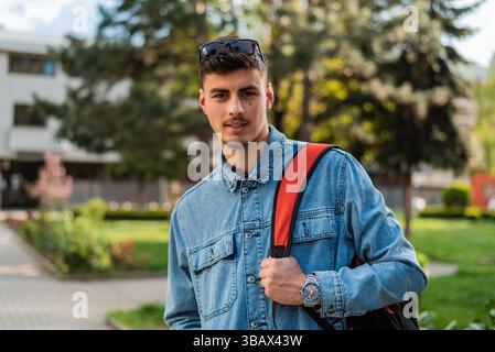 Porträt eines männlichen Studenten auf einem Universitätscampus draußen. Stockfoto