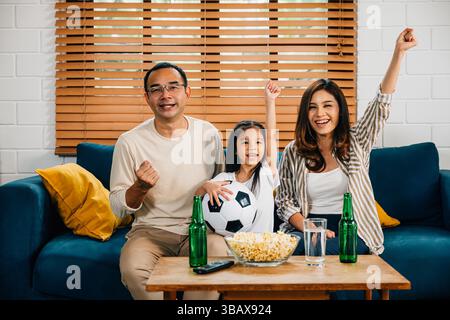 Eine glückliche Familie genießt den Nervenkitzel eines Fußballspiels zu Hause Stockfoto