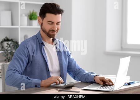 Ein Buchhalter, der im Amt Berechnungen macht Stockfoto