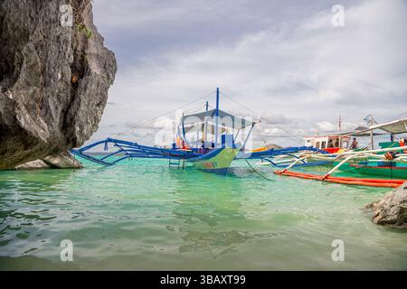 Viele Boote legen am wunderschönen Strand von Coron Island, Philippinen an. Coron ist eine isolierte Vulkaninsel in Palawan auf den Philippinen Stockfoto