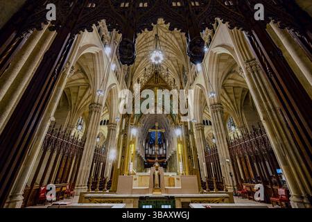 Das Innere der St. Patrick's Cathedral in New York City zeigt neogotische Architektur, Gewölbedecken, goldenen Altar und verzierte Kathedralendetails. Stockfoto