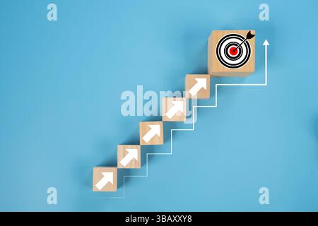 Arrangiert eine Holzblocktreppe mit Zielsymbol. Erreichen von Zielen und Zielen oder eines Konzepts zur Zielsetzung. Erfolgskonzept des Business Growth-Prozesses, c Stockfoto