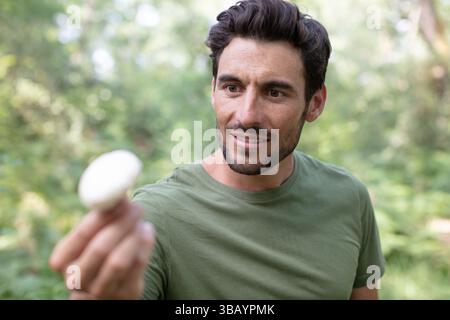 Der Mann fand einen Pilz im Wald Stockfoto