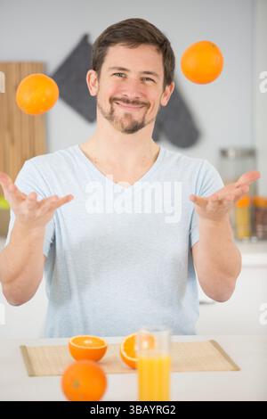Ein Mann, der Orangen jongliert, entsaftet er Stockfoto