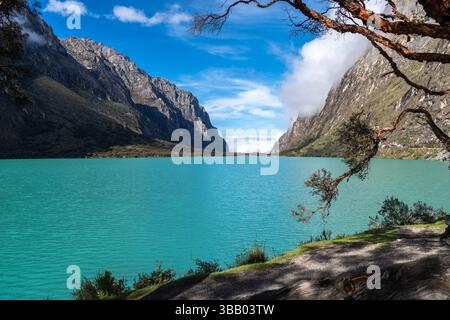 Ein atemberaubender türkisfarbener See reflektiert den blauen Himmel, eingebettet zwischen hoch aufragenden Bergen. Die friedliche Landschaft ist Teil der berühmten Laguna 69 Trek in Hu Stockfoto