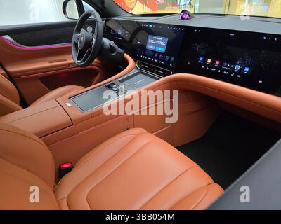 Nahaufnahme des luxuriösen Innenraums aus braunem Leder und des voll digitalen Armaturenbretts eines AITO M9 SUV in einem Tech Showroom. Stockfoto